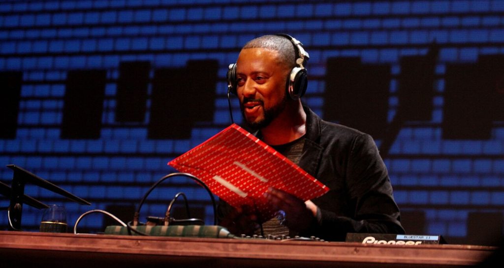 Madlib wearing headphones holding book