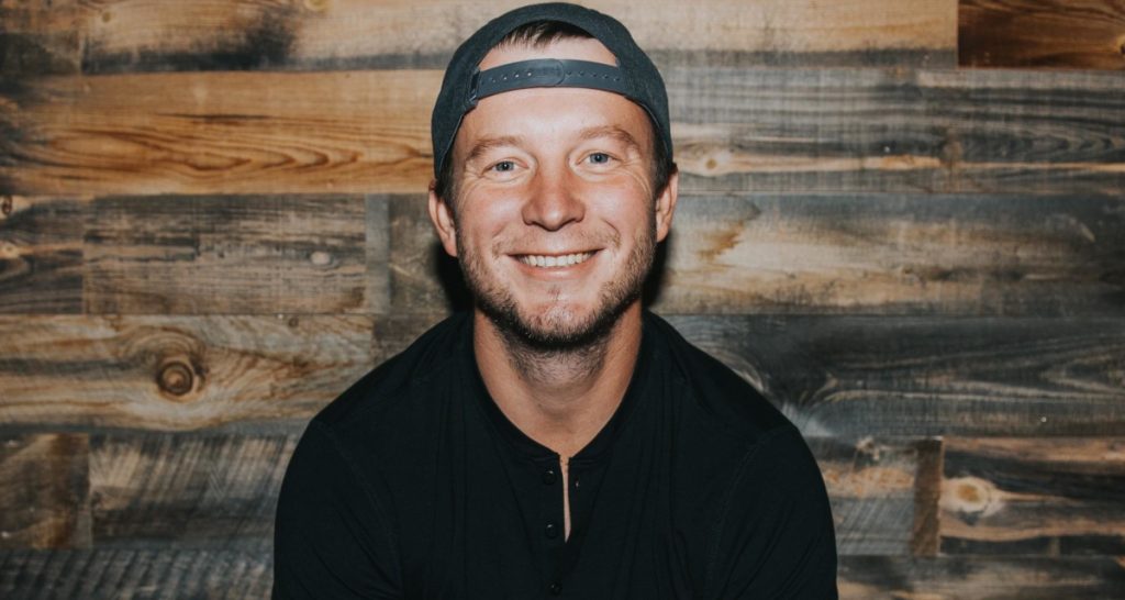 Man with cap smiling at camera