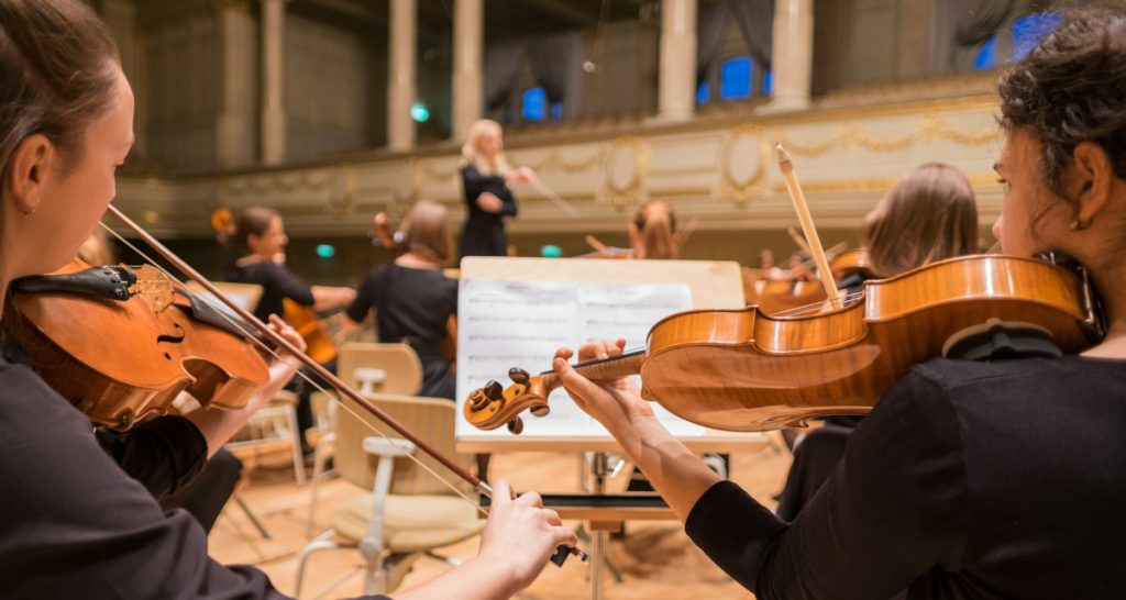 Orchestra violinists performing on stage