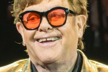 Elton John wearing tinted medical glasses