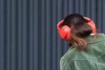 Woman listening with orange headphones