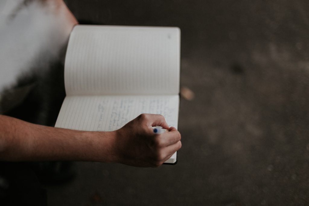 Woman writing on notebook at desk