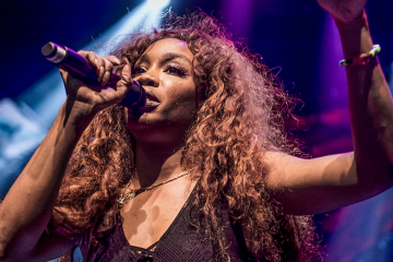 SZA singing into microphone