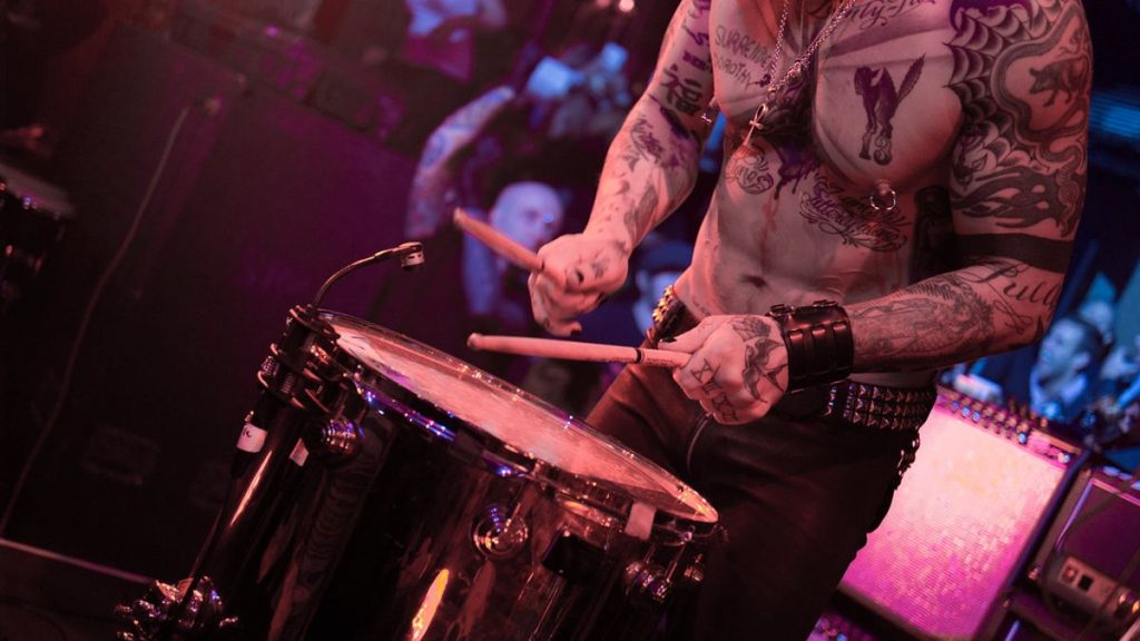 Tattooed drummer performing live show