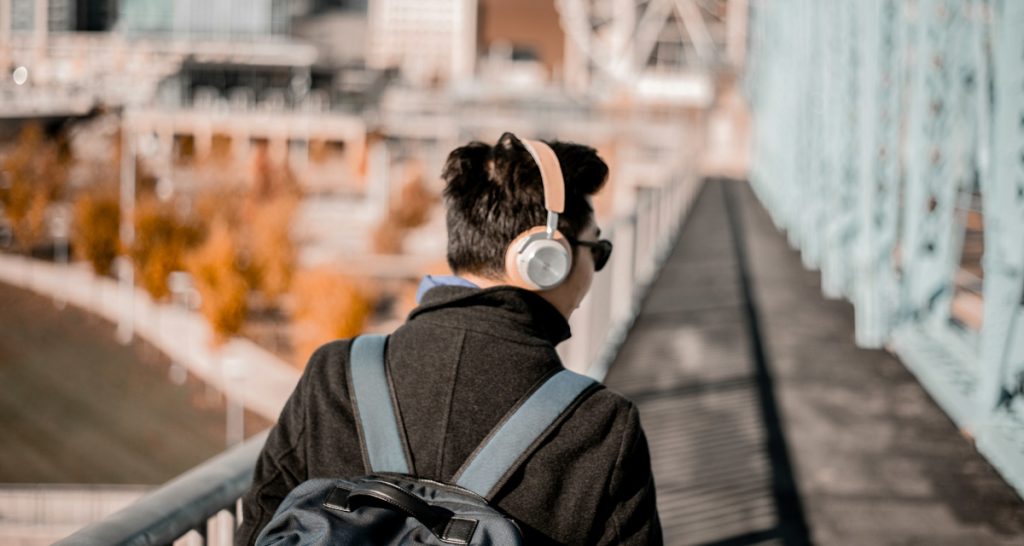 Man streaming music on bridge