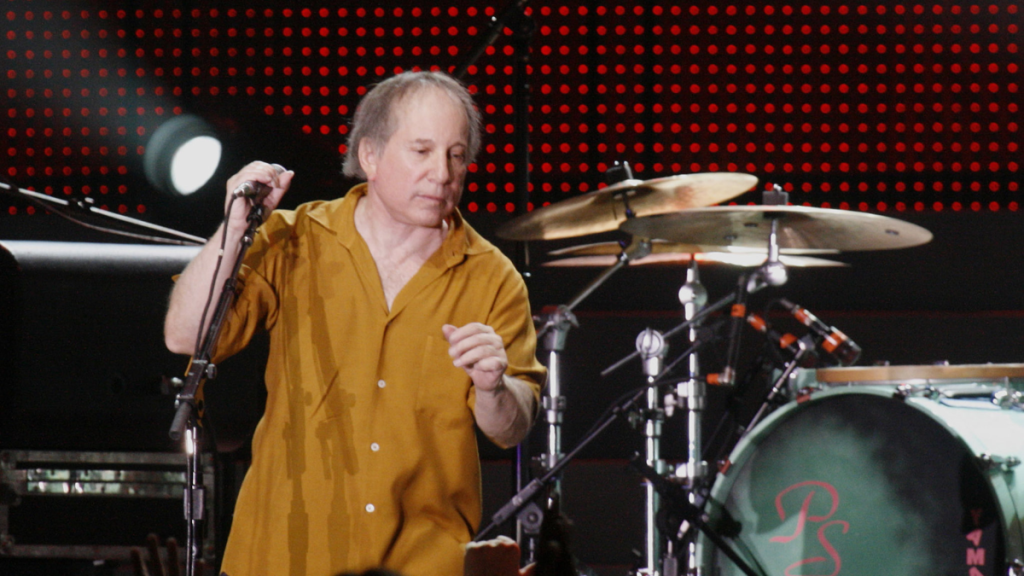 Paul Simon performs at drum set