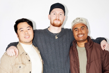 Three men smiling at record label